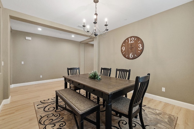 dining area with light hardwood / wood-style flooring and a chandelier