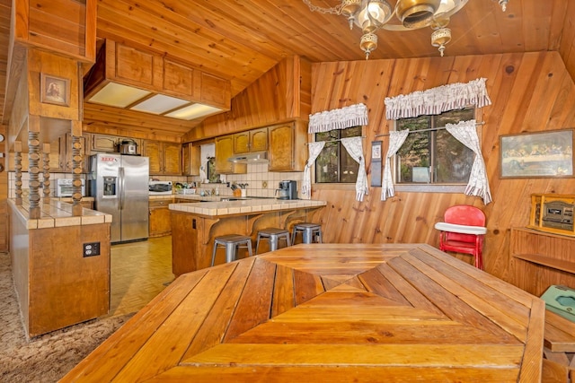 dining area featuring wood ceiling, wood walls, lofted ceiling, and light parquet floors