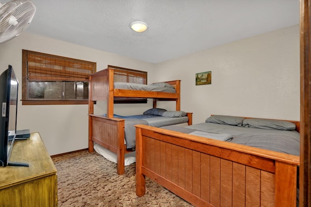 bedroom featuring a textured ceiling and light colored carpet