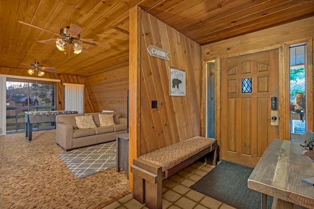 entrance foyer featuring wood walls, wood ceiling, and plenty of natural light