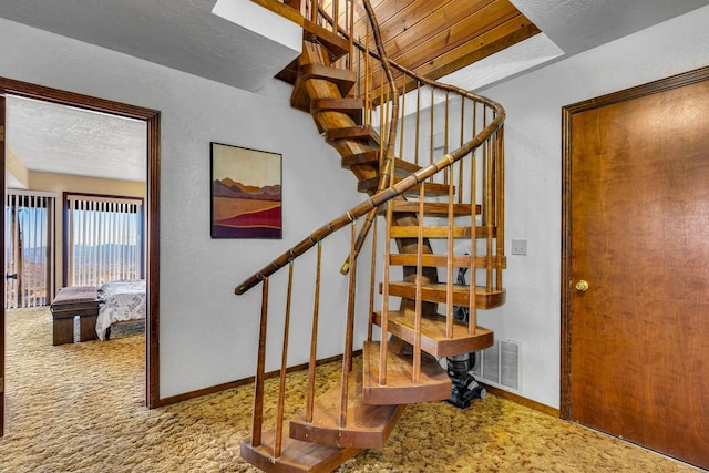 stairway featuring carpet floors and wooden ceiling