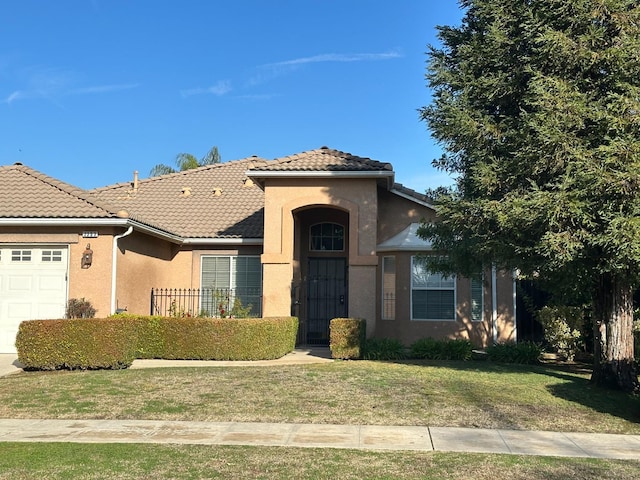 view of front of house with a garage, a tiled roof, a front lawn, and stucco siding