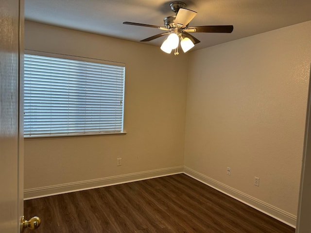 spare room featuring dark wood-type flooring, ceiling fan, and baseboards