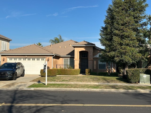 view of front of property with driveway, a tiled roof, an attached garage, a front lawn, and stucco siding