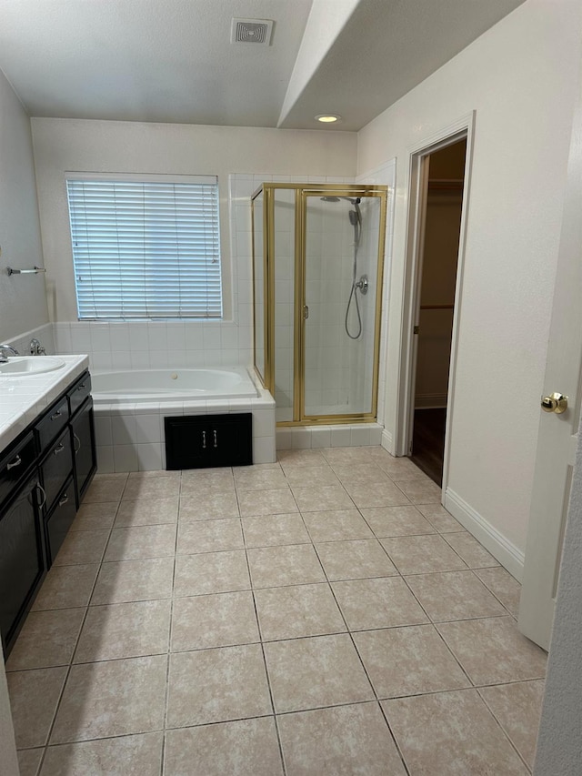 bathroom featuring tile patterned floors, visible vents, a spacious closet, a shower stall, and a bath