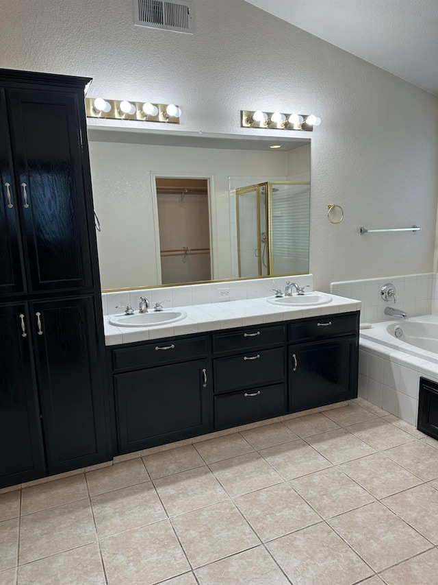 bathroom featuring a stall shower, a sink, visible vents, and tile patterned floors