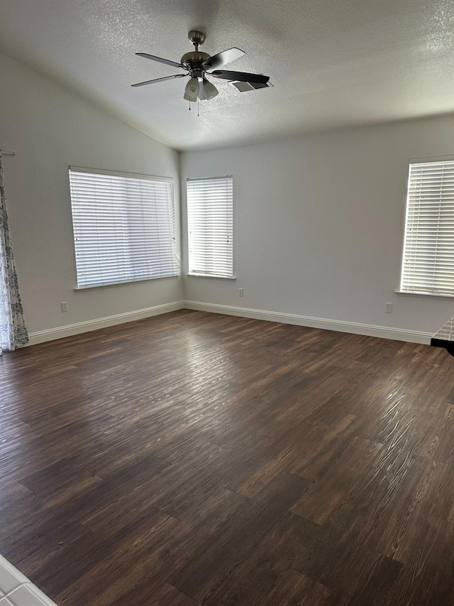 spare room featuring a ceiling fan, dark wood finished floors, a textured ceiling, and baseboards