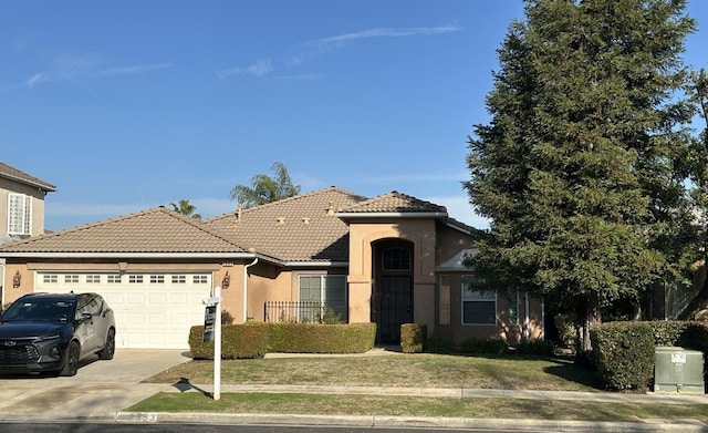 view of front facade with a tile roof, stucco siding, concrete driveway, an attached garage, and a front lawn