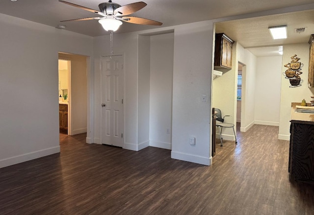 empty room with sink, dark wood-type flooring, a textured ceiling, and ceiling fan