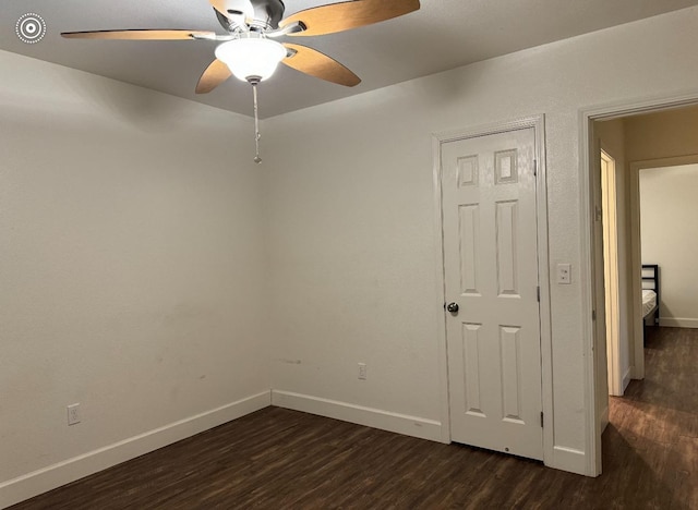 empty room featuring dark wood-type flooring and ceiling fan