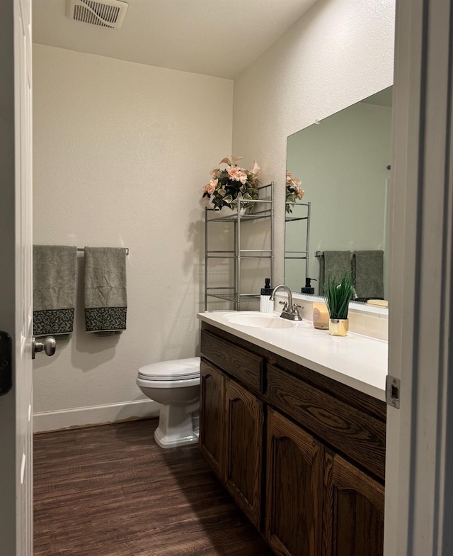 bathroom with vanity, hardwood / wood-style flooring, and toilet