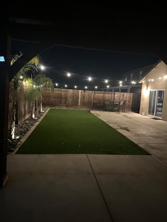 yard at night with a patio