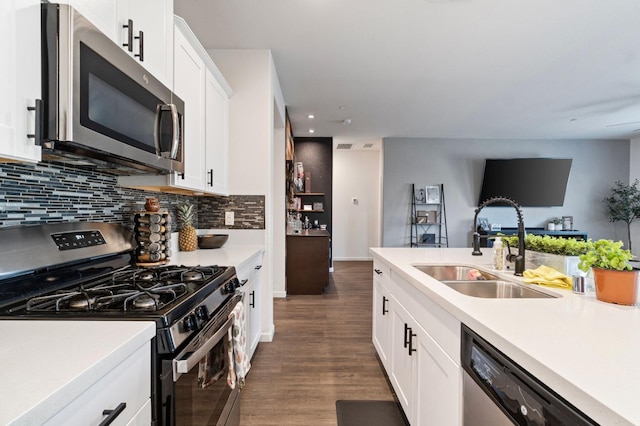 kitchen with backsplash, dark hardwood / wood-style flooring, stainless steel appliances, sink, and white cabinetry