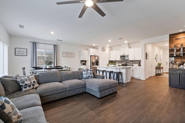 living room with ceiling fan and dark hardwood / wood-style floors