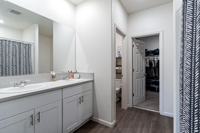 bathroom with hardwood / wood-style floors, vanity, and toilet