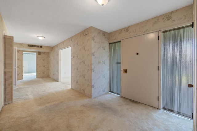 unfurnished room featuring light colored carpet