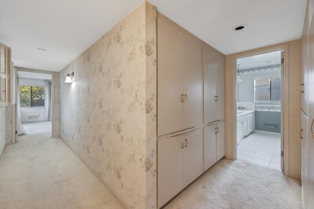 hallway featuring light colored carpet