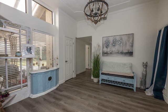 foyer with dark wood-type flooring, a notable chandelier, and ornamental molding