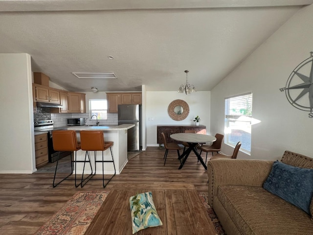 kitchen with a kitchen island, dark wood-type flooring, sink, a kitchen bar, and appliances with stainless steel finishes