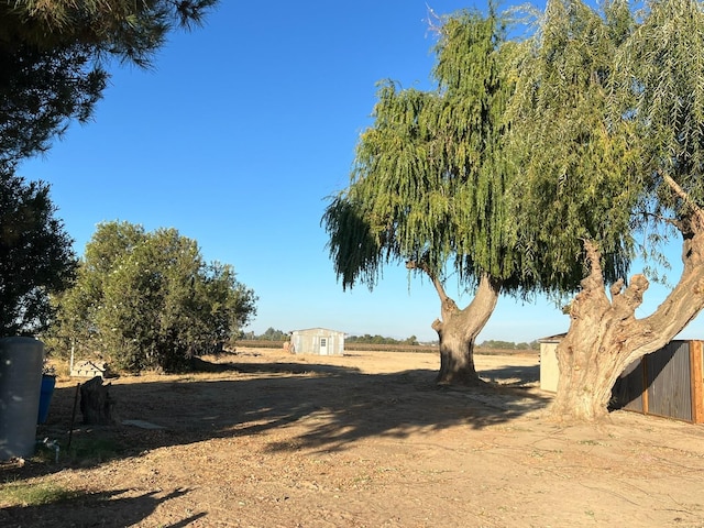 view of yard featuring a storage unit and a rural view