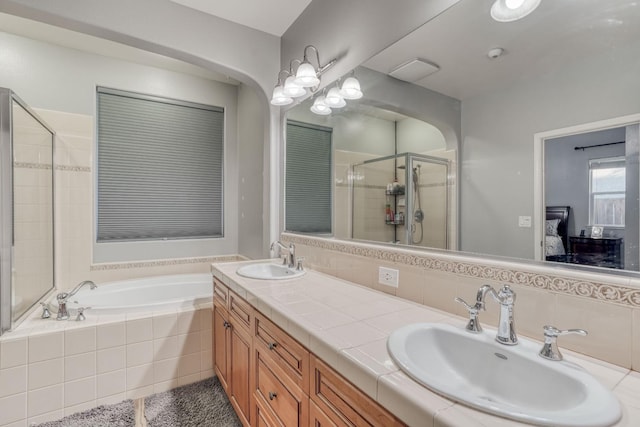 bathroom featuring vanity, tasteful backsplash, and independent shower and bath