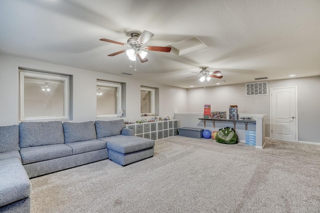 living room featuring ceiling fan, a textured ceiling, and carpet floors