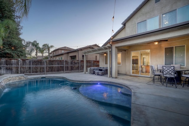 pool at dusk with a patio area