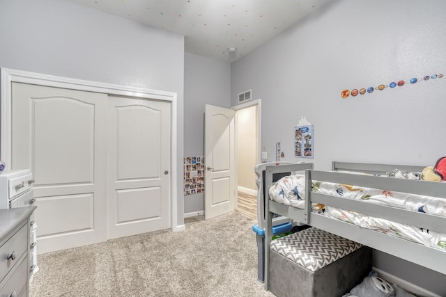 bedroom featuring light carpet and a closet