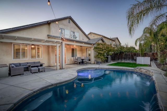 pool at dusk with an outdoor hangout area, pool water feature, a patio area, and a pergola