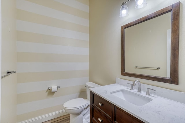 bathroom with vanity, wood-type flooring, and toilet