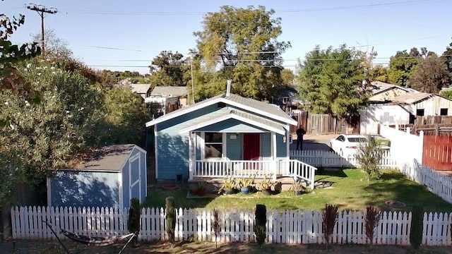 view of front facade with a front lawn, covered porch, and a storage shed