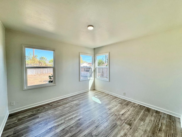 unfurnished room featuring dark hardwood / wood-style floors and a textured ceiling