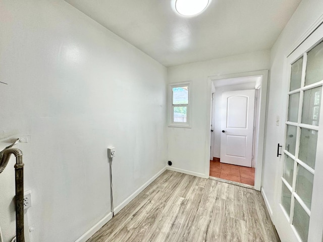 laundry area featuring hookup for an electric dryer and light hardwood / wood-style flooring