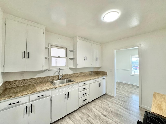 kitchen with white cabinetry, light hardwood / wood-style floors, sink, and plenty of natural light