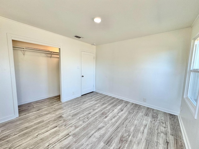 unfurnished bedroom with a closet and light hardwood / wood-style floors