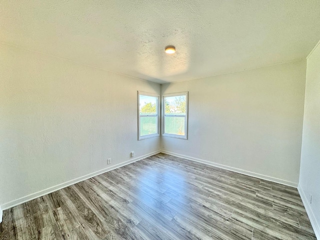 spare room featuring a textured ceiling and wood-type flooring