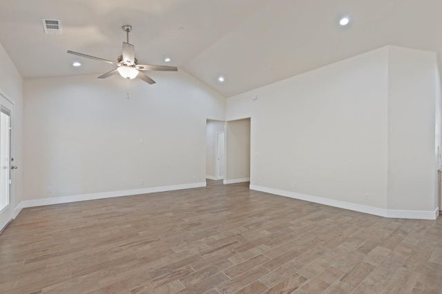 spare room with lofted ceiling, visible vents, light wood-style floors, a ceiling fan, and baseboards