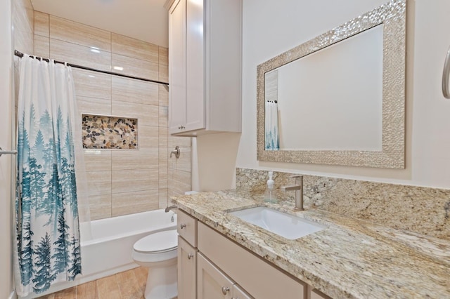 full bath with toilet, shower / tub combo, wood finished floors, and vanity