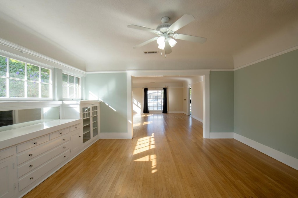 spare room with crown molding, light hardwood / wood-style flooring, and ceiling fan