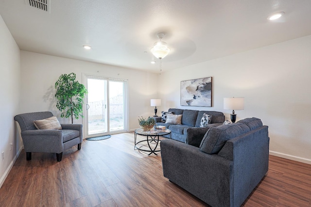 living room with ceiling fan and dark wood-type flooring