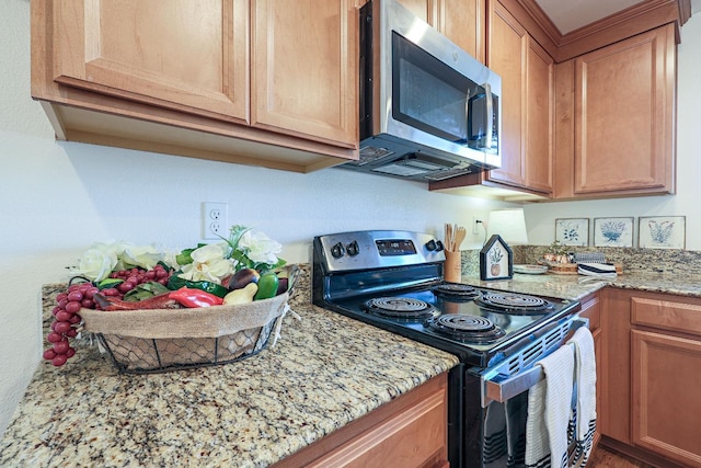 kitchen with black electric range and light stone counters