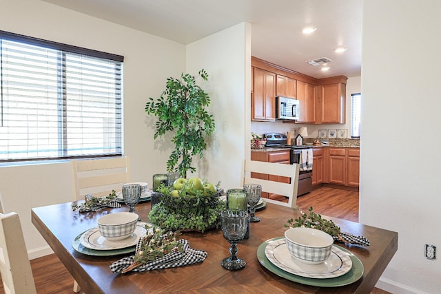 dining area with light hardwood / wood-style flooring and a healthy amount of sunlight