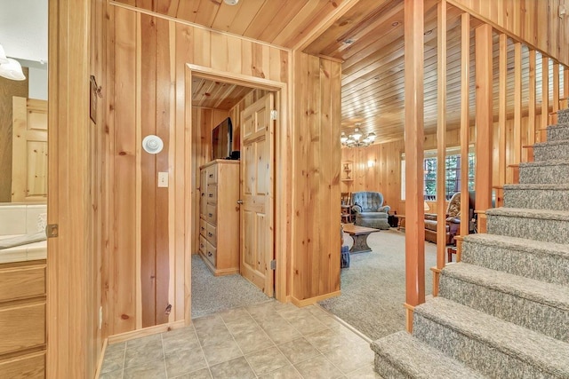 stairs with wood ceiling, wood walls, and carpet flooring