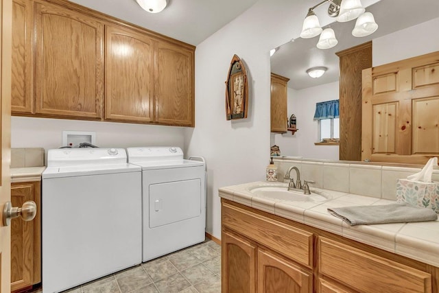 clothes washing area with cabinets, independent washer and dryer, sink, and light tile patterned floors