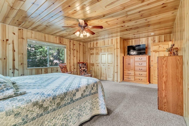 carpeted bedroom featuring ceiling fan, wood ceiling, and wooden walls