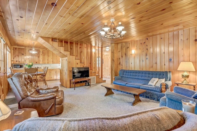 carpeted living room with an inviting chandelier, wooden walls, and wooden ceiling