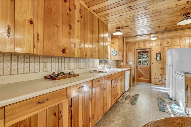 kitchen featuring white appliances, light tile patterned flooring, sink, wood ceiling, and wooden walls