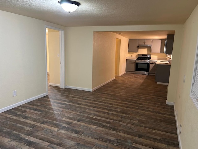 unfurnished living room with dark hardwood / wood-style floors, sink, and a textured ceiling