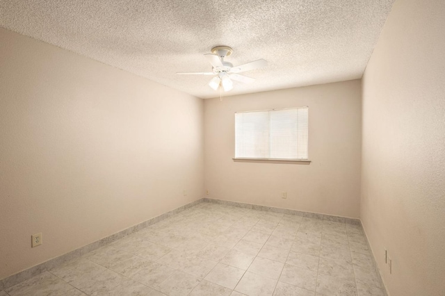 unfurnished room with ceiling fan and a textured ceiling