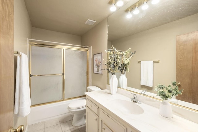 full bathroom with toilet, tile patterned floors, bath / shower combo with glass door, and vanity